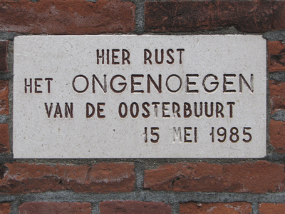 905718 Afbeelding van de gevelsteen 'HIER RUST HET ONGENOEGEN VAN DE OOSTERBUURT 15 MEI 1985', in de gevel van het pand ...